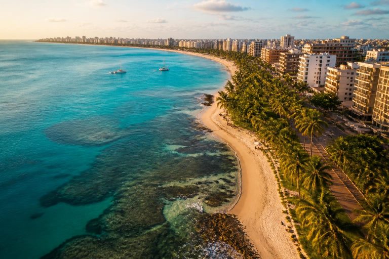 Praias de Maceió com mar azul-turquesa e coqueirais na orla